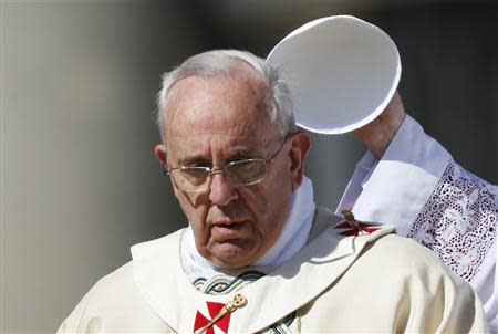 Pope Francis has his hat removed as he leads the Easter mass in Saint Peter's Square at the Vatican April 20, 2014. REUTERS/Tony Gentile