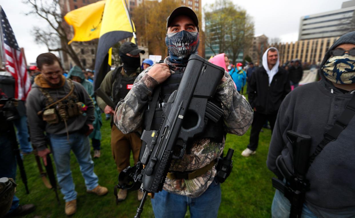 A protester carries his rifle at the state Capitol in Lansing, Michigan, on April 30, 2020. Hoisting U.S. flags and handmade signs, protesters denounced Gov. Gretchen Whitmer's stay-at-home order and business restrictions amid the pandemic. (Photo: Paul Sancya/ASSOCIATED PRESS)