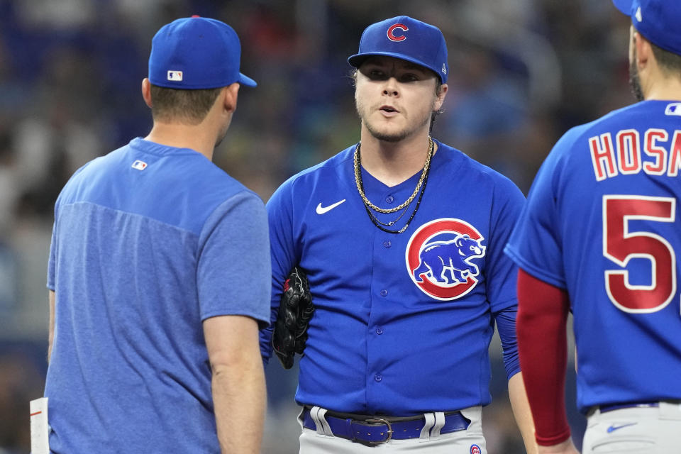 Chicago Cubs starting pitcher Justin Steele, center, talks to pitching coach Mel Stollemyre during the third inning of a baseball game against the Miami Marlins, Sunday, April 30, 2023, in Miami. (AP Photo/Marta Lavandier)