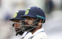 India's captain Virat Kohli, right, and batting partner Cheteshwar Pujara wait to walk into the field after the lunch break during the second day of the World Test Championship final cricket match between New Zealand and India, at the Rose Bowl in Southampton, England, Saturday, June 19, 2021. (AP Photo/Ian Walton)