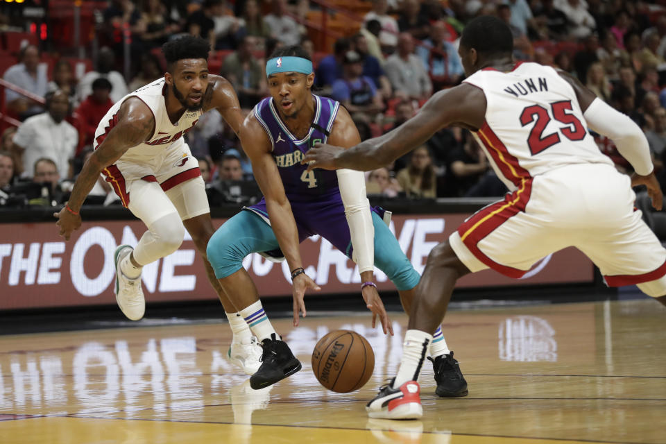 Charlotte Hornets guard Devonte' Graham (4) drives to the basket past Miami Heat guard Kendrick Nunn (25) and forward Derrick Jones Jr. during the first half of an NBA basketball game, Wednesday, March 11, 2020, in Miami. (AP Photo/Wilfredo Lee)