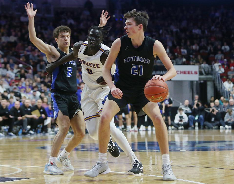 Waukee Northwest guard Pryce Sandfort (21) attempts to drive around Waukee forward Omaha Biliew (0) during the first quarter in the class 4A boys state basketball semifinal.