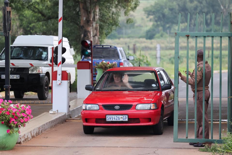 A car drives past the gates as a Correctional Services officer stands guard at the entrance of the Atteridgeville Correctional Centre, where South African athlete Oscar Pistorius, convicted of killing his girlfriend Reeva Steenkamp in 2013, is due to be released on parole, in Pretoria, South Africa (Reuters)
