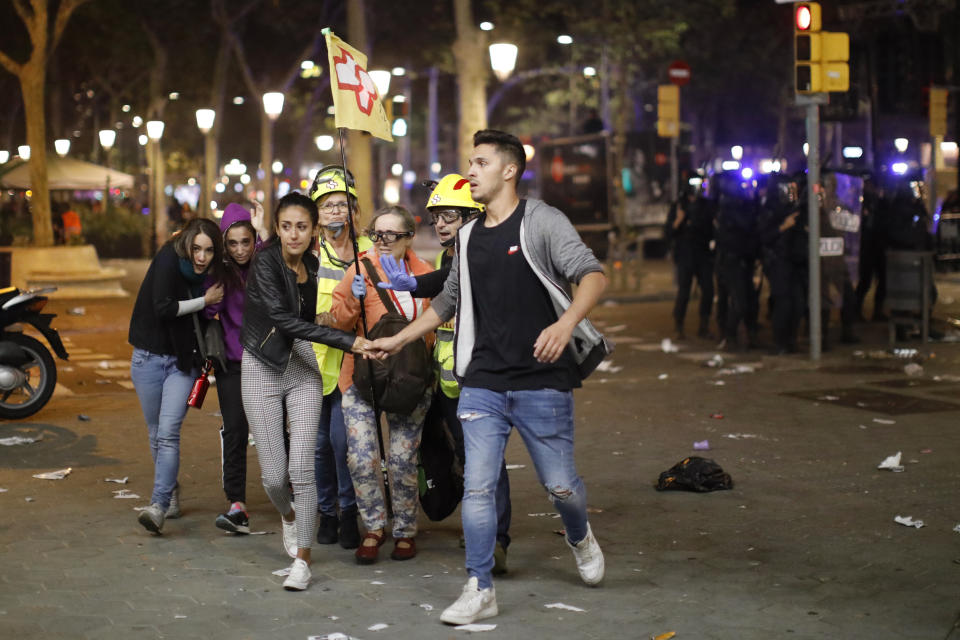 Un pequeño grupo camina junto a dos paramédicos (AP Photo/Emilio Morenatti)