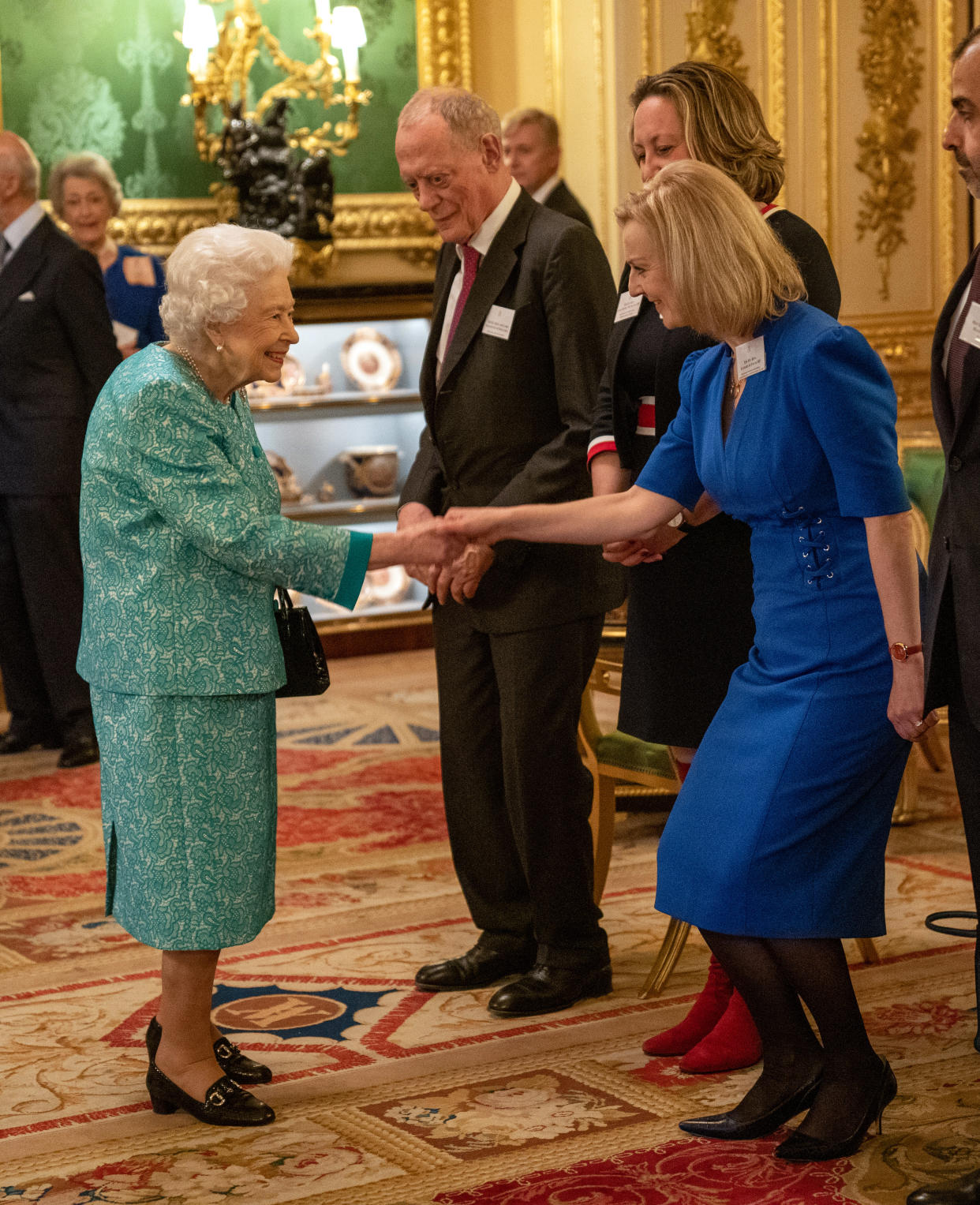 Queen Elizabeth II greets Foreign Secretary Liz Truss (right) at a reception for international business and investment leaders at Windsor Castle, to mark the Global Investment Summit. Picture date: Tuesday October 19, 2021.