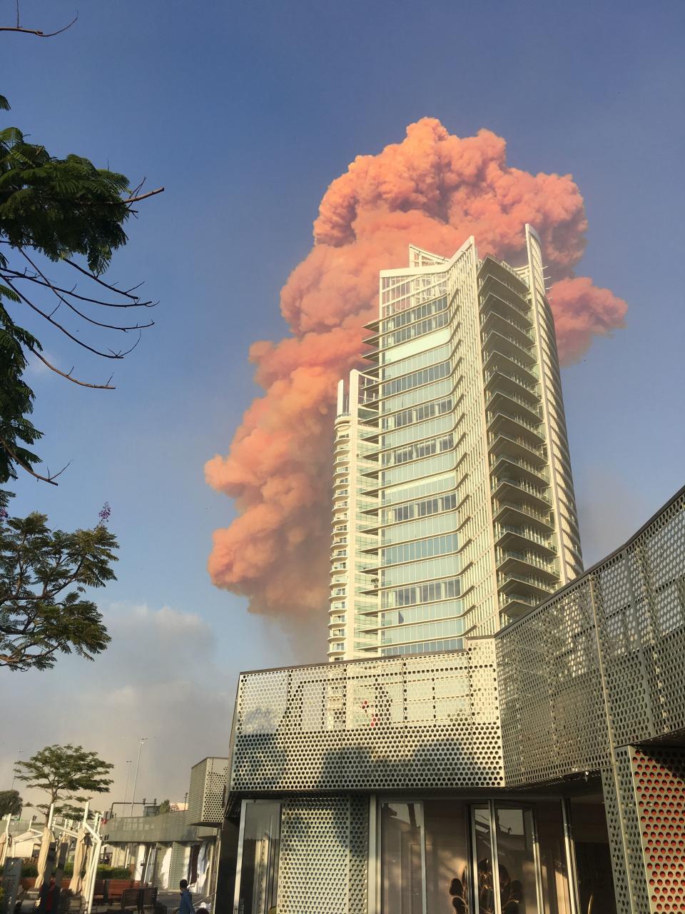 EDITORS NOTE: Graphic content / A photo taken from Zaytouna Bay shows a red plume of fire behind a highrise in central Beirut just after a huge explosion rocked the Lebanese capital on August 4, 2020. - Two huge explosion rocked the Lebanese capital Beirut, wounding dozens of people, shaking buildings and sending huge plumes of smoke billowing into the sky. Lebanese media carried images of people trapped under rubble, some bloodied, after the massive explosions, the cause of which was not immediately known. (Photo by Bassem EL HAGE / AFP) (Photo by BASSEM EL HAGE/AFP via Getty Images)