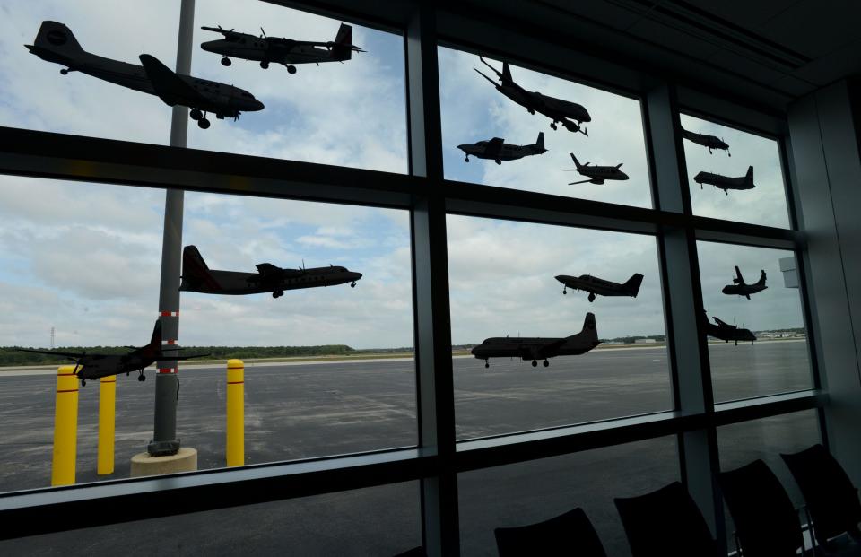 Decals of aircraft through the years which have flown out of the Cape Cod Gateway Airport fill the viewing windows of a waiting area at the Hyannis airport.