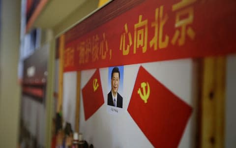 A picture shows Chinese President Xi Jinping's portrait during an exhibition displaying China's achievements for the past five years in Beijing - Credit: Reuters