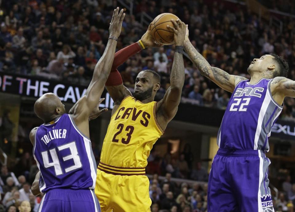 Sacramento Kings' Anthony Tolliver (43) and Matt Barnes (22) defend Cleveland Cavaliers' LeBron James (23) during the second half of an NBA basketball game, Wednesday, Jan. 25, 2017, in Cleveland. The Kings won 116-112. (AP Photo/Tony Dejak)