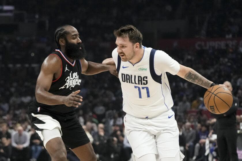 The Clippers' James Harden pressures the Mavericks' Luka Doncic, who is dribbling the ball