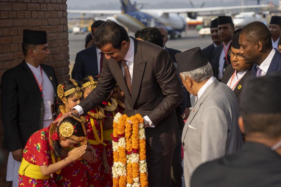 Qatar's Emir Sheikh Tamim bin Hamad Al Thani, greets one of the children who received him upon his arrival at the airport in Kathmandu, Nepal, Tuesday, April 23, 2024. The emir is on a two-days visit to the Himalayan nation. (AP Photo/Niranjan Shreshta)