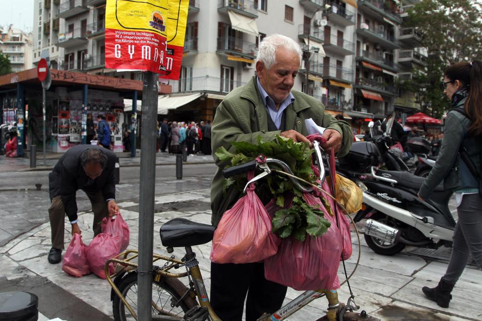 A man carries his produce after Greek farmers' market vendors distributed free produce as part of a protest in the northern Greek city of Thessaloniki, Wednesday, April 30, 2014, after their trading association launched an indefinite strike Monday. The market vendors are the latest professional group in Greece to protest a sweeping liberalization drive demanded by rescue creditors. (AP Photo/Nikolas Giakoumidis)