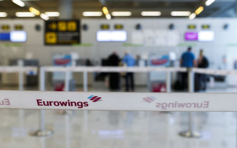 German tourists stand at Eurowings check-in counters at Son Sant Joan airport in Palma de Mallorca