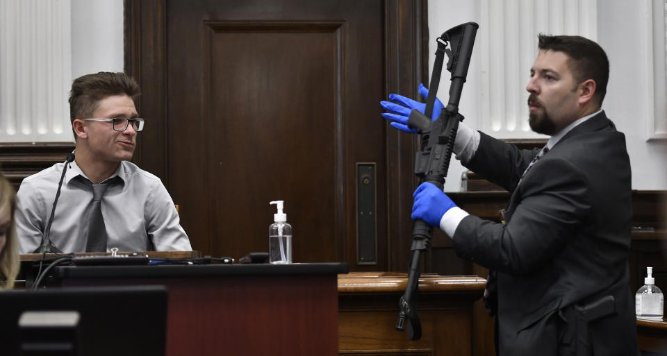 FILE - Dominick Black, left, identifies the rifle Kyle Rittenhouse used on Aug. 25, 2020 during Rittenhouse's trial at the Kenosha County Courthouse in Kenosha, Wis, on Nov. 2, 2021. Black, who bought an AR-15-style rifle for Kyle Rittenhouse has pleaded no contest to a reduced charge of contributing to the delinquency of a minor in a deal with prosecutors to avoid prison. A Wisconsin judge accepted Dominick Black's plea on Monday, Jan. 10, 2022. (Sean Krajacic/The Kenosha News via AP, Pool File)