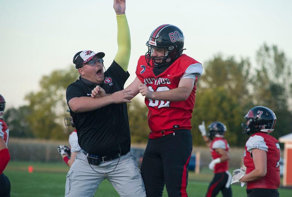 Bucyrus' Gabe Higginbotham celebrates a big play with assistant coach Nick Kohler.