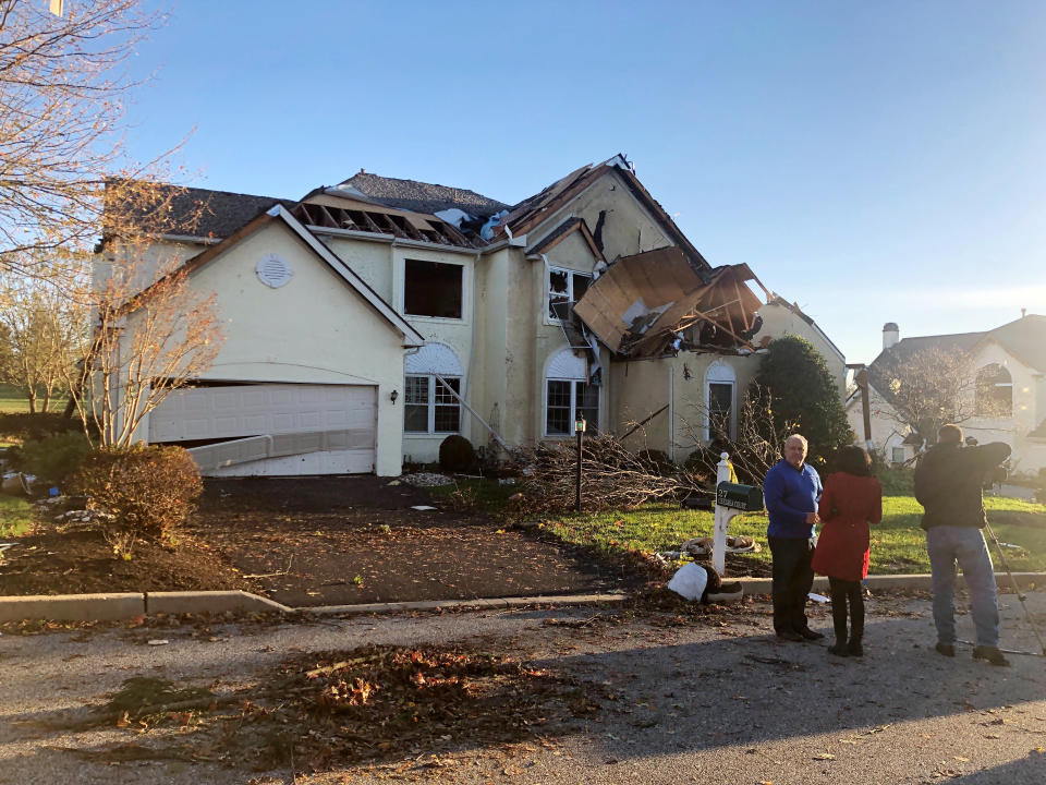 People stand in front of house damaged by Thursday nights severe weather in Thornbury Township, Pa., on Friday, Nov. 1, 2019. Homes have been destroyed in Pennsylvania and hundreds of thousands of utility customers were left without power after severe thunderstorms struck the Eastern Seaboard. At least 420,000 customers from South Carolina up to Maine and in Ohio were without power just before midnight Thursday. (Anna Orso/The Philadelphia Inquirer via AP)