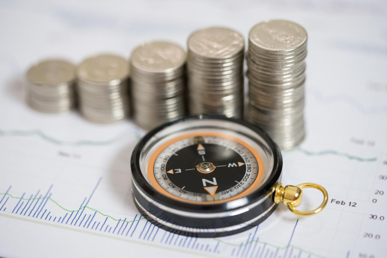 Close up compass and coin stack on income document , finance concept.