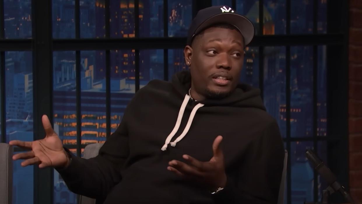  Michael Che talking with his hands on Late Night with Seth Meyers. 