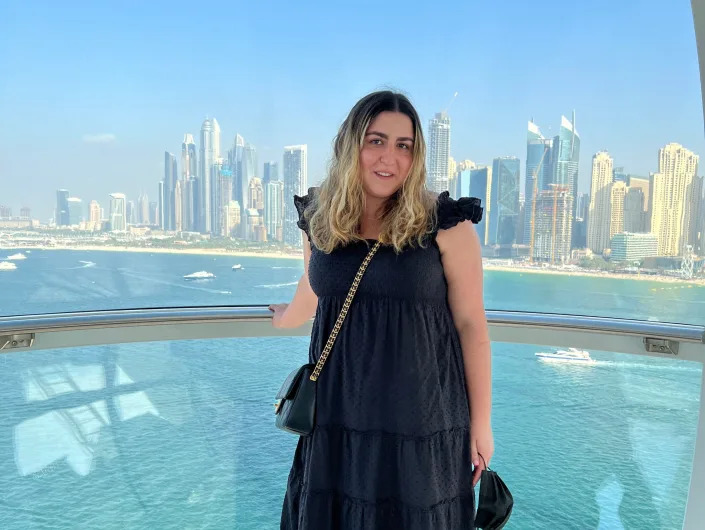 The writer poses in front of city skyline on the Ain Dubai
