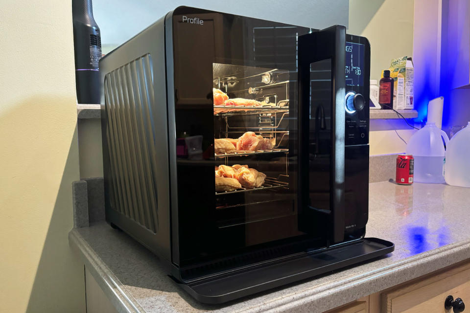 <p>GE Profile Smart Indoor Smoker has just started smoked chicken wings. Photo is from the left corner, interior light is on.</p>
