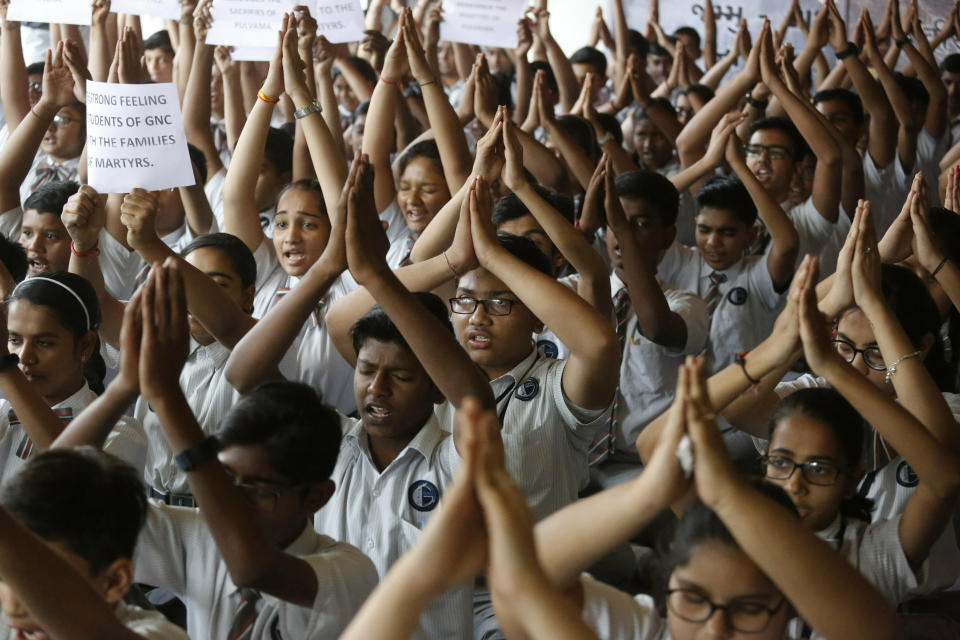 Indian students offer prayers during a function to pay tribute to paramilitary soldiers killed in Thursday's explosion in Kashmir, at a school in Ahmadabad, India, Friday, Feb. 15, 2019. The death toll from a car bombing on a paramilitary convoy in Indian-controlled Kashmir has climbed at least 40, becoming the single deadliest attack in the divided region's volatile history, security officials said Friday. (AP Photo/Ajit Solanki)