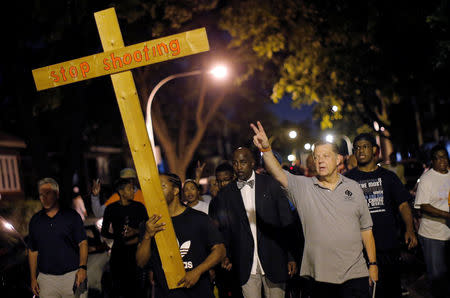 Father Michael Pfleger (3rd R) marches through the streets of a South Side neighborhood during a weekly night-time peace demonstration in Chicago, Illinois, September 16, 2016. REUTERS/Jim Young
