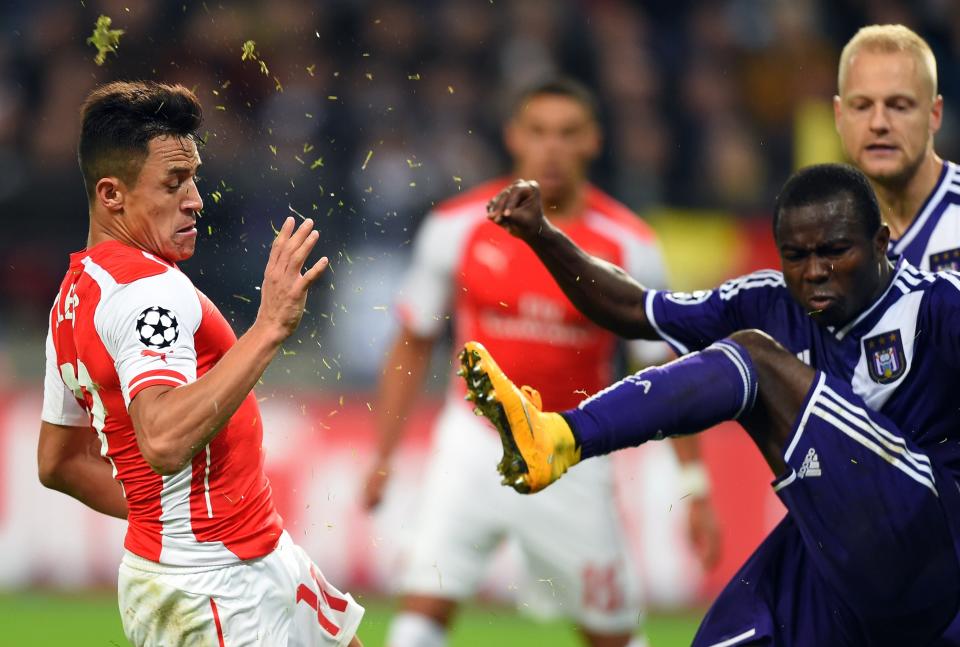 Anderlecht's forward from Ghana Frank Acheampong (R) kicks out by Arsenal's Chilean striker Alexis Sanchez in a UEFA Champions League group stage football match Anderlecht vs Arsenal at the Constant Vanden Stock stadium in Anderlecht on October 22, 2014.
