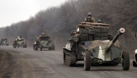 Members of the Ukrainian armed forces ride armoured personnel carriers as they pull back from Debaltseve region, near Artemivsk February 26, 2015. REUTERS/Gleb Garanich