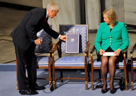 The Norwegian Nobel Committee chairman Thorbjorn Jagland (L) puts the diploma on the empty chair where Nobel Peace Prize winner Liu Xiaobo should sit during the Nobel Peace Prize ceremony in Oslo, December 10, 2010. REUTERS/Toby Melville/Files