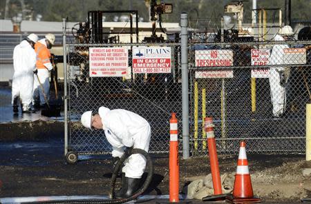 Workers clean up spilled oil at a facility in Los Angeles, May 15, 2014. REUTERS/Phil McCarten