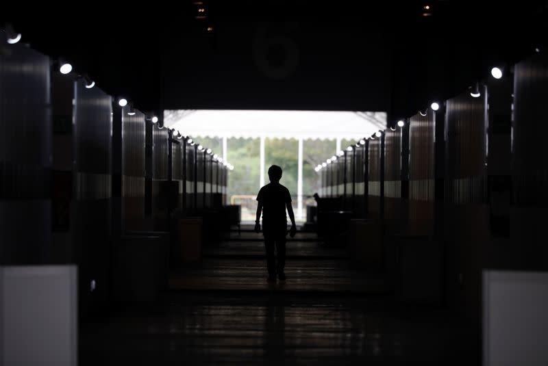 A man walks past partitioned rooms at Changi Exhibition Centre which has been repurposed into a community isolation facility, in Singapore
