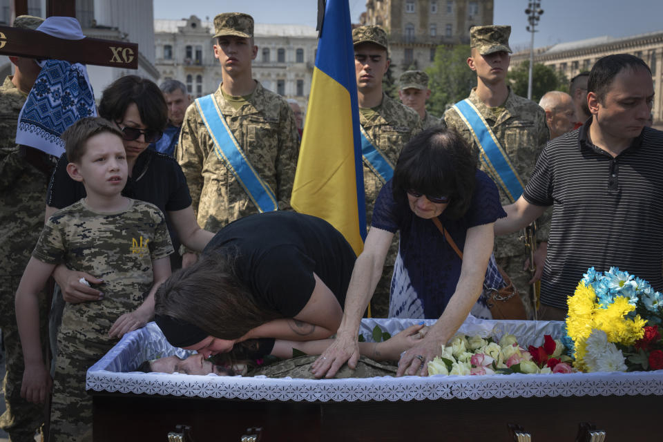 A boy stands near the coffin of his father, volunteer soldier Ivan Shulga, a sound producer in TV channels and musician, killed in a battle with the Russian troops near Bakhmut, during a farewell ceremony in Independence Square in Kyiv, Ukraine, Tuesday, June 20, 2023. (AP Photo/Efrem Lukatsky)