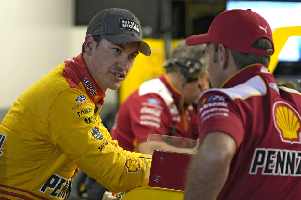 Joey Logano, left, talks to a crew member after a practice for the NASCAR Daytona 500 auto race Friday, Feb. 17, 2023, at Daytona International Speedway in Daytona Beach, Fla. (AP Photo/Chris O'Meara)