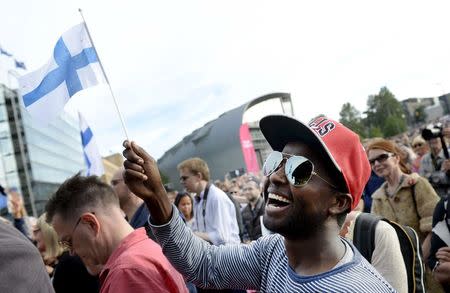 Mire Ibrahim waves the Finnish flag during a demonstration against racism where an estimated 15,000 people attended in Helsinki, Finland on July 28th, 2015. REUTERS/Vesa Moilanen/Lehtikuva