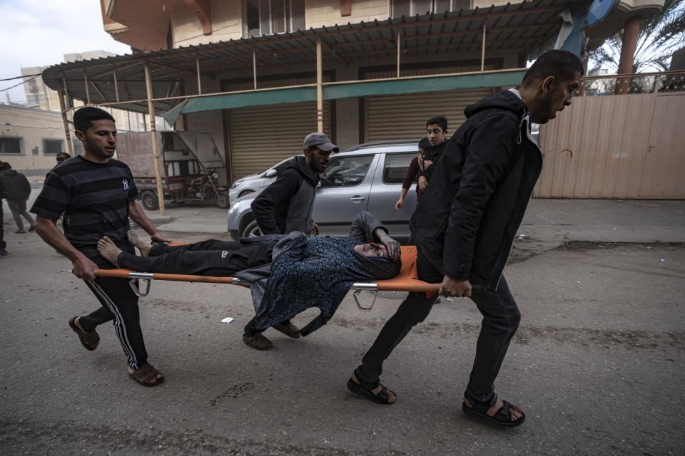 Palestinians evacuate a wounded woman from a site hit by an Israeli bombardment on Rafah, southern Gaza Strip, Wednesday, Dec. 20, 2023. (AP Photo/Fatima Shbair)