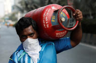 A man carries a gas cylinder as he waits to purchase cooking gas after India ordered a 21- day nationwide lockdown to limit the spreading of coronavirus disease (COVID-19) in Mumbai, India March 27, 2020. REUTERS/Francis Mascarenhas