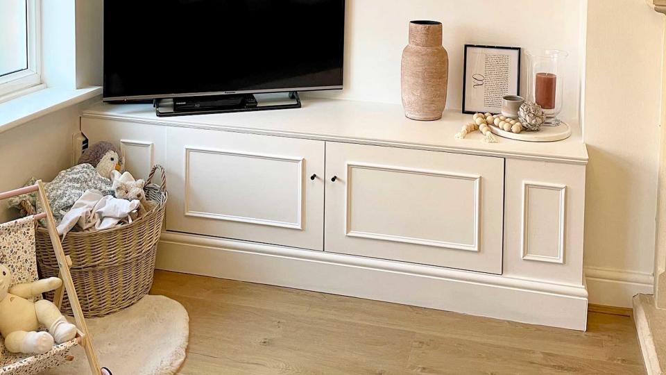 A sideboard with moldings on it, with a TV placed on top