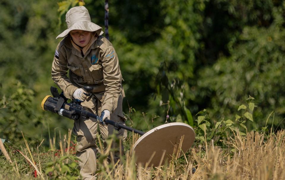 A technician searches carefully for unexploded munitions