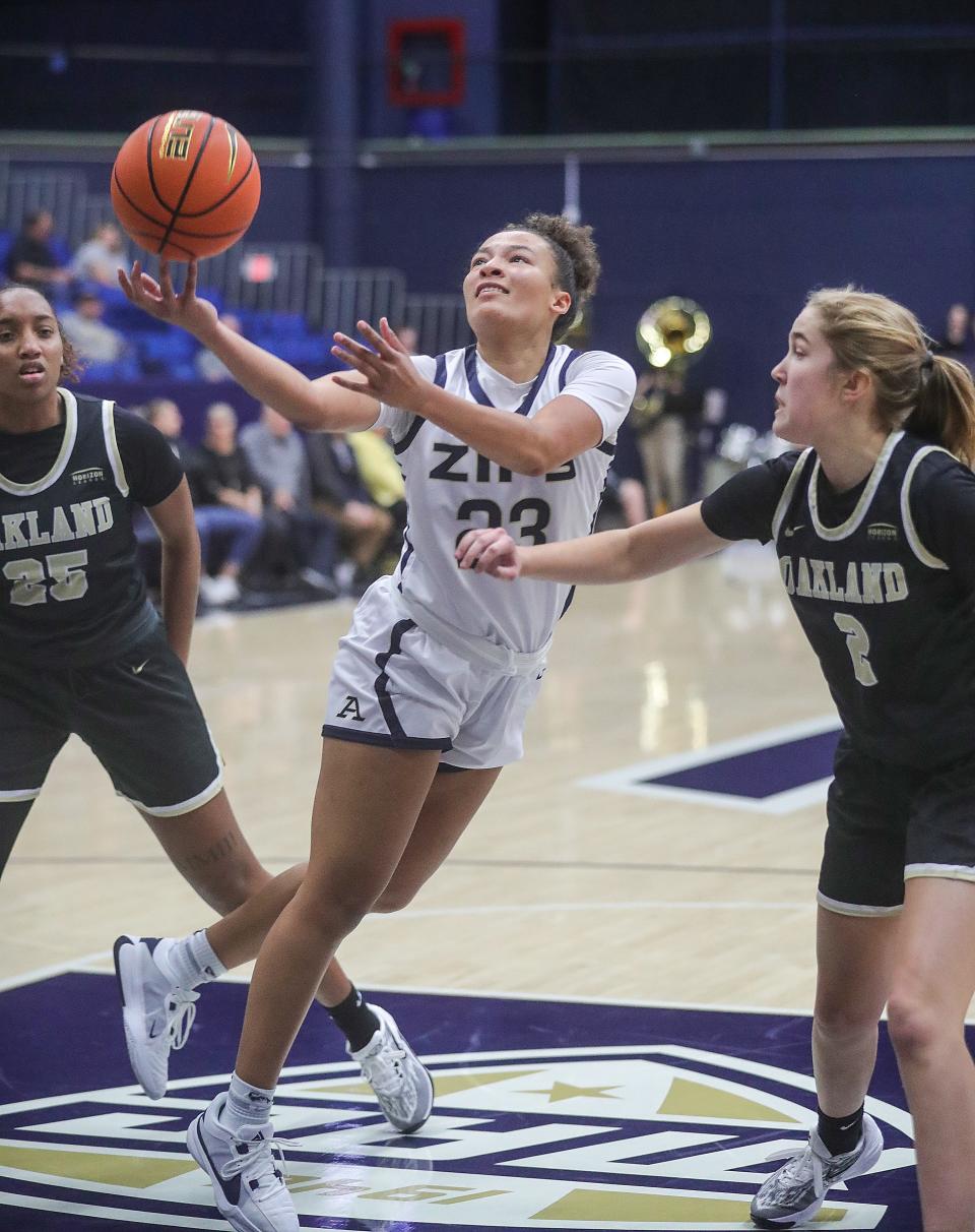 University of Akron guard Zakia Rasheed puts up a shot in the paint between Oakland defenders Kennedie Montue, left, and Maddy Skorupski on Monday in Akron.