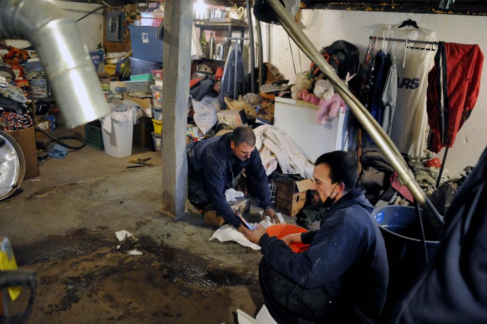 Jennings Heating and Cooling installers Ryan Trump, left, and Michael Ellis, are prepare the site for a new furnace in Brenda Deeter's basement. Deeter's of Orrville was the winner of the company's Oldest Furnace Contest, and won a new furnace, installation included.