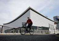 A man wearing a protective mask amid the coronavirus disease (COVID-19) outbreak, cycles past Ariake Arena in Tokyo