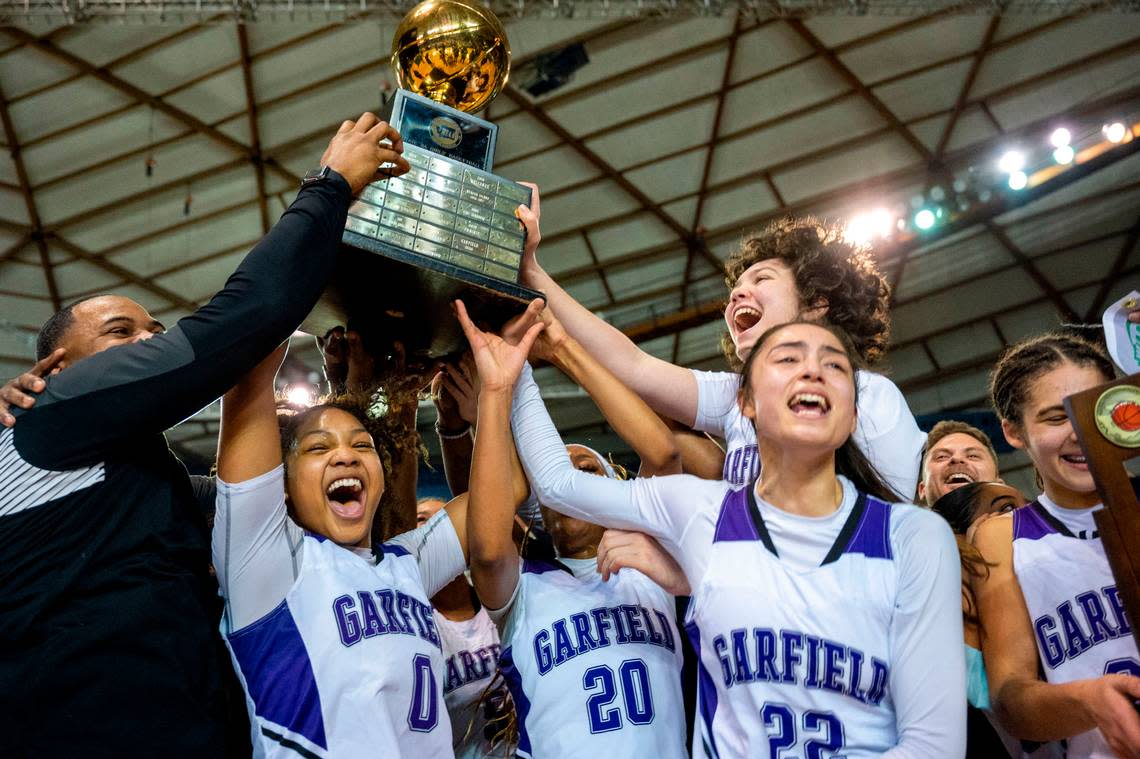 Garfield players hoist the Class 3A state championship trophy after beating Lake Washington, 39-38, on Saturday, March 5, 2022, at the Tacoma Dome, in Tacoma, Wash.