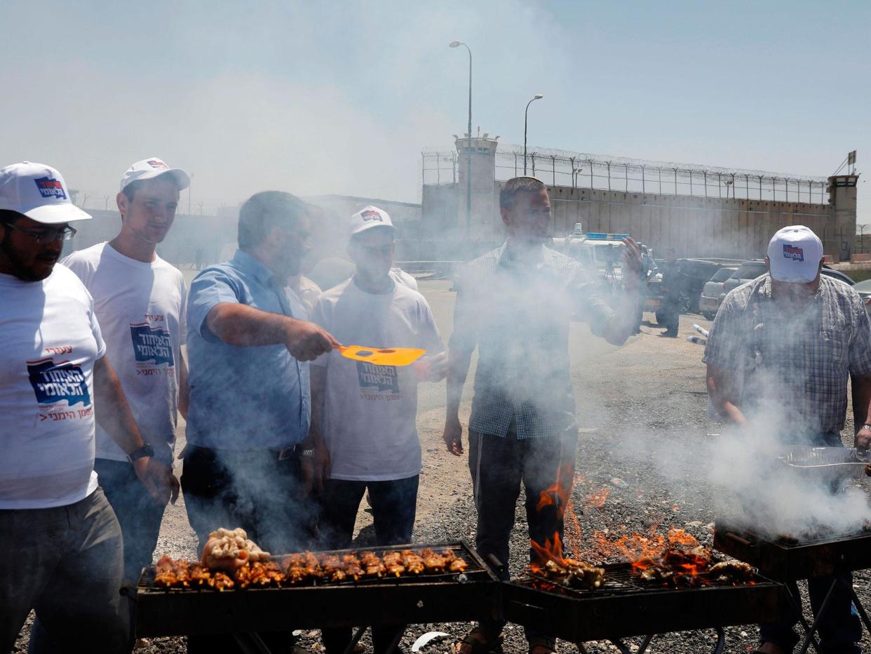 Israeli right-wing activists hold a barbecue outside the Israeli-run Ofer military prison, north of Jerusalem, in the occupied West Bank, where a number of Palestinian prisoners are on a hunger strike: MENAHEM KAHANA/AFP/Getty Images