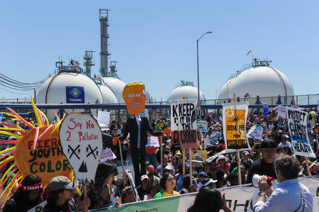 Demonstrators walk on the Pacific Coast highway during People's Climate March protest for the environment in the Wilmington neighborhood in Los Angeles, California, U.S. April 29, 2017. REUTERS/Andrew Cullen