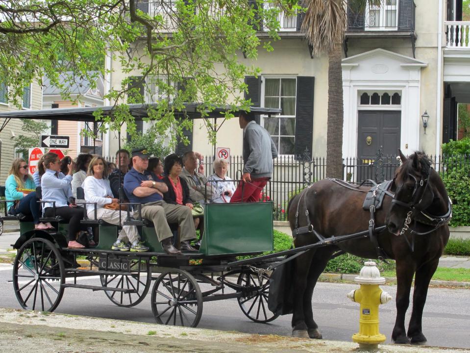 FILE - In this May 3, 2013 file photo, a carriage tour is stopped before a home in the historic Battery in Charleston, S.C. Charleston, the oldest city in South Carolina, was founded in 1670. (AP Photo/Bruce Smith, File)