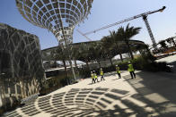 In this Oct. 8, 2019, photo, Associated Press journalists visit the Sustainability Pavilion at the under construction site of the Expo 2020 in Dubai, United Arab Emirates. Its Sustainability Pavilion, which recalls the towers of New York’s 1964 world’s fair, will be covered in solar panels and surrounded by similarly paneled “energy trees” to make it a zero-energy structure. (AP Photo/Kamran Jebreili)
