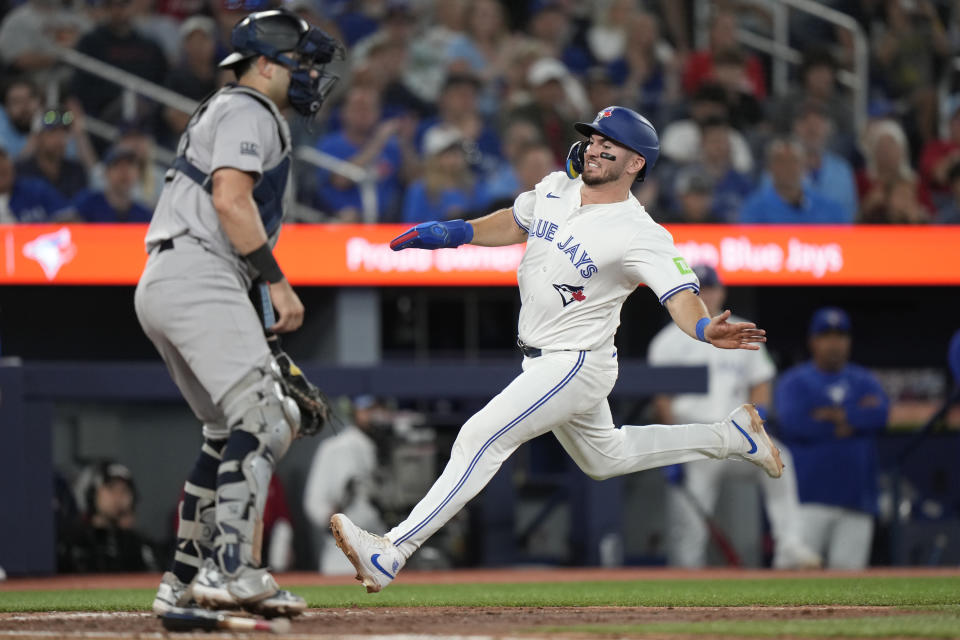 Toronto Blue Jays' Spencer Horwitz, right, scores on a single by teammate Justin Turner during third-inning baseball game action against the New York Yankees in Toronto, Sunday, June 30, 2024. (Frank Gunn/The Canadian Press via AP)