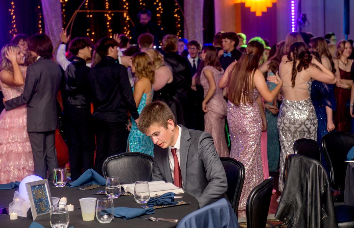 Nathan Teaney dutifully studies for an AP exam while his East Peoria classmates and their dates dance during prom Saturday, May 4, 2024 at the Par-A-Dice Hotel in East Peoria.