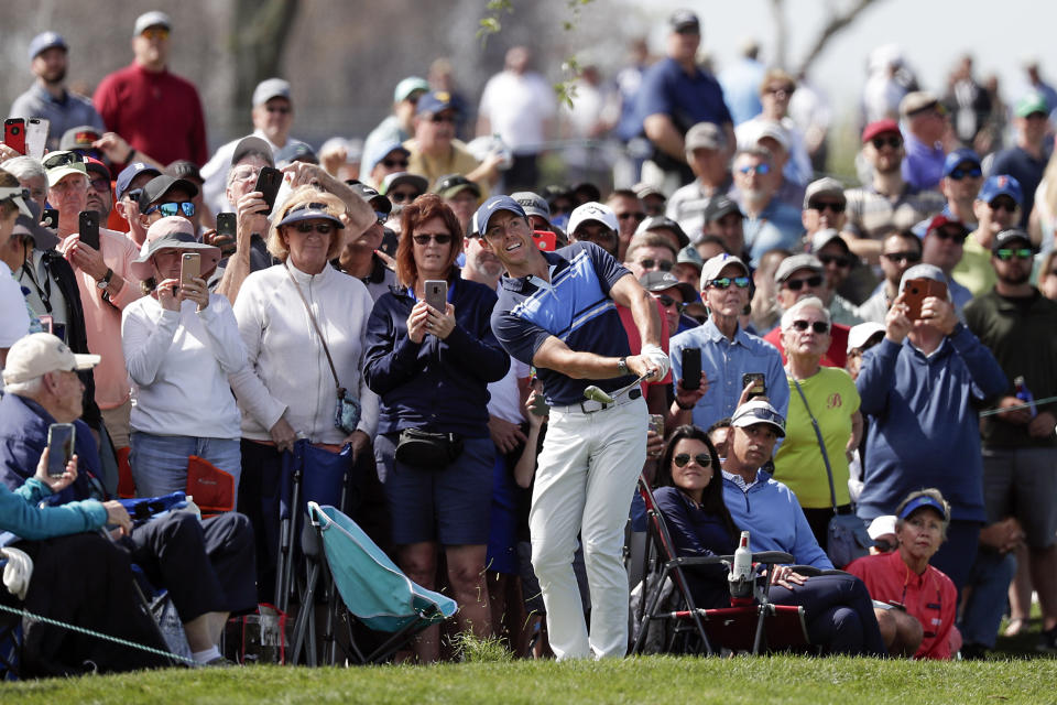 Rory McIlroy, center, of Northern Ireland, hits from the gallery to the sixth green during the second round of the Arnold Palmer Invitational golf tournament Friday, March 6, 2020, in Orlando, Fla. (AP Photo/John Raoux)