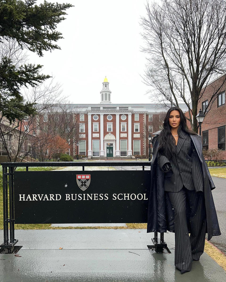 Kim Kardashian posing next to a Harvard Business School sign